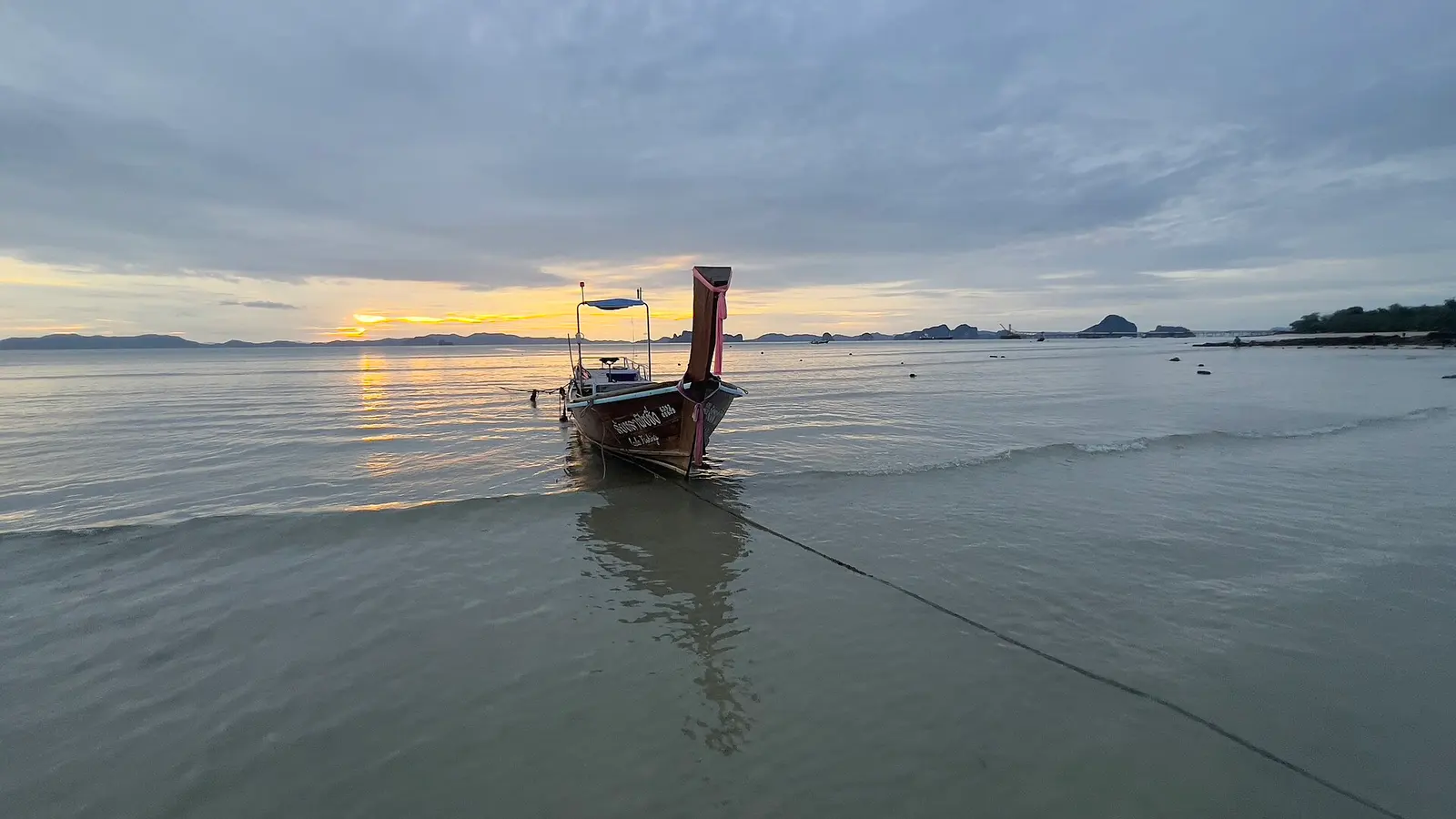 Klong Muang beach, a wide sandy shore with a limestone island across calm water