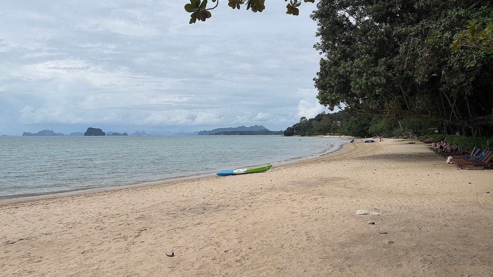 Tubkaek Beach in Krabi at low tide, pale sand and limestone islands on the horizon