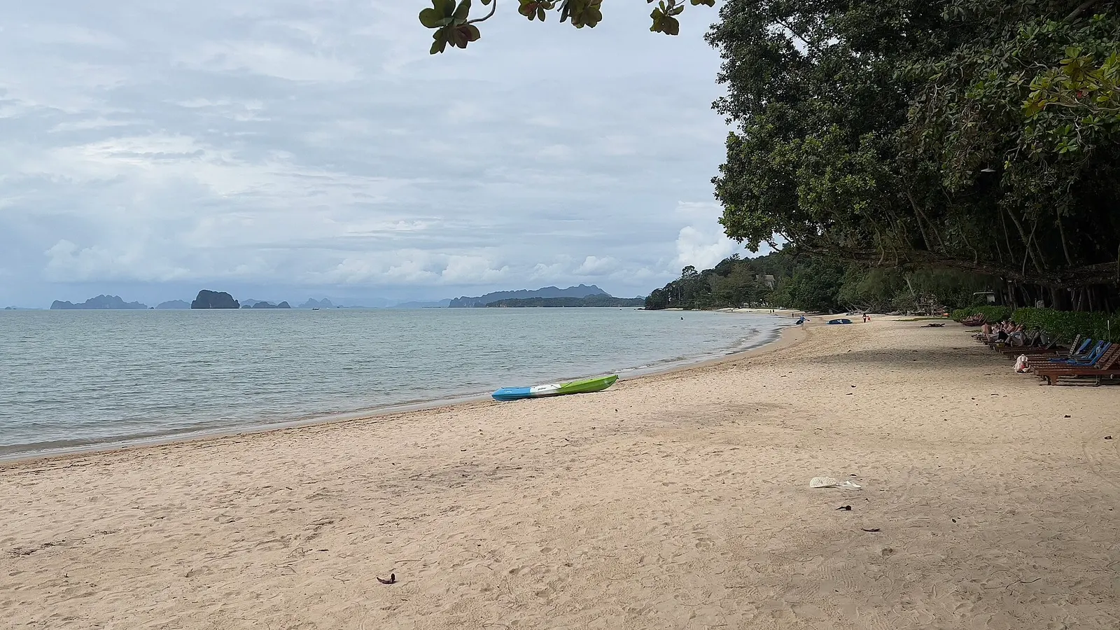 Tubkaek Beach at low tide, pale sand and limestone islands on the horizon