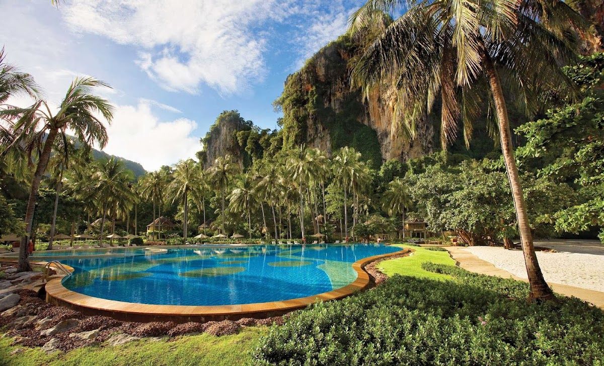 Rayavadee Resort pool surrounded by limestone cliffs and tropical palms at Railay Beach, Krabi